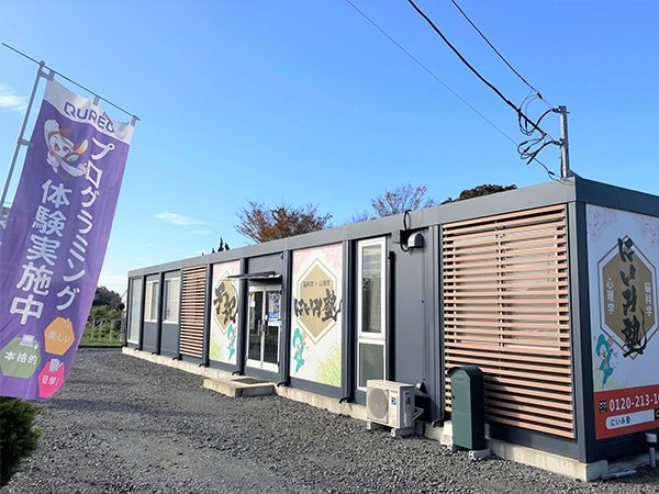 にいみ塾の建物の外観。横に長い平屋で、入口が並んでいる