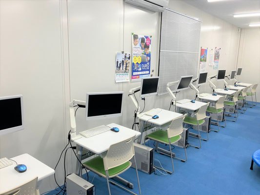 壁に沿って間隔をあけて並ぶ学習席とパソコン
